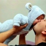 папа целует ребенка в пижамке